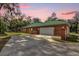 Attached brick garage with white door and driveway at 1908 S Farm Rd, Deland, FL 32720