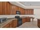 Kitchen with dark wood cabinets, granite countertops, and built-in oven at 1908 S Farm Rd, Deland, FL 32720