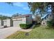 Front view of charming townhouse with attached garage and well-manicured lawn at 235 Pine Cone Trl, Ormond Beach, FL 32174