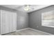 Simple bedroom with grey walls, wood-look floors, and ceiling fan at 2888 Berkshire Woods Ter, Deltona, FL 32725