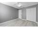 Charming bedroom with grey walls, wood-look floors, and double doors to closet at 2888 Berkshire Woods Ter, Deltona, FL 32725