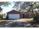 Cute ranch home with a white garage door and mature landscaping at 3019 N Covington Dr, Deltona, FL 32738
