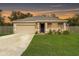 Beige house with a two-car garage and a well-manicured lawn at 304 Gardenia Ave, Debary, FL 32713