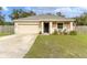 Tan house with a two-car garage and American flag at 304 Gardenia Ave, Debary, FL 32713
