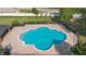 Aerial view of a community pool surrounded by brick pavers and mature landscaping at 3125 Wood Rose Way, Deltona, FL 32725