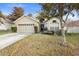 Tan house with a two-car garage and a well-maintained lawn at 3125 Wood Rose Way, Deltona, FL 32725