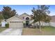 Tan two-story house with a three-car garage at 3125 Wood Rose Way, Deltona, FL 32725