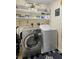 Bright laundry room with washer, dryer, and ample shelving at 3125 Wood Rose Way, Deltona, FL 32725