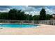 Community pool with surrounding brick patio and fence at 3125 Wood Rose Way, Deltona, FL 32725