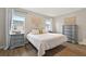 Spacious bedroom with a king-size bed, gray dresser, and wood floors at 37 Bella Lago Cir, Port Orange, FL 32129