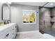Updated bathroom with modern vanity, large mirror and walk-in shower at 373 Blythville Ave, Deltona, FL 32725