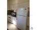 White appliances and wood cabinets in this galley kitchen at 5108 Cassatt Ave, Orlando, FL 32808