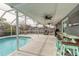 Spacious screened-in pool patio, perfect for entertaining, featuring an outdoor bar, grill, and comfortable seating areas at 559 Eagle Dr, Daytona Beach, FL 32117