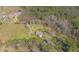 Aerial view of a house with a pool and deck on a large property with mature trees and distant water at 601 Rasley Rd, New Smyrna Beach, FL 32168