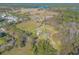 Aerial view of a house on a large property with a pond nearby, surrounded by lush green landscape at 601 Rasley Rd, New Smyrna Beach, FL 32168