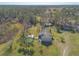 Aerial view of a house with a pool and deck on a large property with mature trees at 601 Rasley Rd, New Smyrna Beach, FL 32168