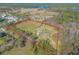 Aerial view of a house on a large property with surrounding trees and distant water at 601 Rasley Rd, New Smyrna Beach, FL 32168
