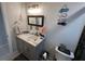 Bright bathroom featuring a white vanity with marble countertops, framed mirror, and decorative beach themed accents at 744 Baywood Ln, South Daytona, FL 32119