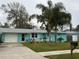 Charming light blue house with a well-manicured lawn and palm trees at 744 Baywood Ln, South Daytona, FL 32119