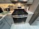Stainless steel gas range and oven with gray cabinets and marble countertops at 744 Baywood Ln, South Daytona, FL 32119