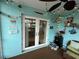 Enclosed patio with string lights, fan and decorations leads indoors through white framed glass doors at 744 Baywood Ln, South Daytona, FL 32119