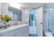 Bathroom with white vanity, large mirror, and shower at 925 N Halifax Ave # 1001, Daytona Beach, FL 32118
