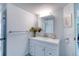Bright bathroom with white vanity, mirror, and flowers at 925 N Halifax Ave # 1001, Daytona Beach, FL 32118
