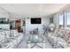 Living area with two floral sofas, a coffee table, and a large TV at 925 N Halifax Ave # 1001, Daytona Beach, FL 32118