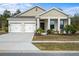 Tan two-car garage house with landscaping and a porch at 2861 Monaghan Dr, Ormond Beach, FL 32174