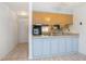 Kitchen with light wood cabinets and a light blue breakfast bar at 100 E Kentucky Ave # K106, Deland, FL 32724