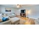 Bright living room with L-shaped sofa, wood floors, and large windows at 1036 Tompkins Dr, Port Orange, FL 32129
