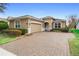 Single-story home with a brick driveway and well-manicured landscaping at 1105 Gardenshire Ln, Deland, FL 32724
