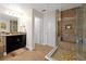 Bathroom with double vanity, walk-in shower, and built-in storage at 1106 Woods Landing Dr, Minneola, FL 34715