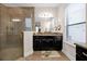 Modern bathroom featuring a walk-in shower, double vanity, and dark cabinetry at 1106 Woods Landing Dr, Minneola, FL 34715