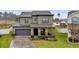 Two-story house with stone accents, two-car garage, and landscaped yard at 1106 Woods Landing Dr, Minneola, FL 34715