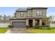 Two-story house with stone accents and a dark-colored garage door at 1106 Woods Landing Dr, Minneola, FL 34715