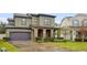 Two-story house with stone accents and a dark-colored garage door at 1106 Woods Landing Dr, Minneola, FL 34715