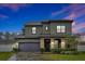 Two-story house with stone accents and a dark-colored garage door at 1106 Woods Landing Dr, Minneola, FL 34715