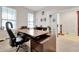 Home office with large desk, ample natural light, and neutral decor at 1106 Woods Landing Dr, Minneola, FL 34715