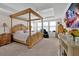 Luxurious main bedroom with large four-poster bed and ensuite bathroom at 1106 Woods Landing Dr, Minneola, FL 34715