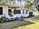 Charming white brick home featuring a metal roof and well-maintained landscaping at 1122 Ne 9Th St, Ocala, FL 34470