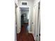 Long hallway with hardwood floors and doors to rooms at 1122 Ne 9Th St, Ocala, FL 34470