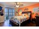 Bedroom with orange walls, a ceiling fan, and coastal-themed bedding at 1224 S Peninsula Dr # 511, Daytona Beach, FL 32118