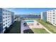 Community pool with surrounding patio furniture, lush landscaping, and river views at 1224 S Peninsula Dr # 511, Daytona Beach, FL 32118