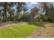 Spacious backyard with artificial grass, established landscaping, and wooden fence at 1240 W Voorhis Ave, Deland, FL 32720