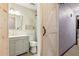 Stylish bathroom with modern vanity, mirror, toilet, wood-look tile, and a sliding barn door at 1240 W Voorhis Ave, Deland, FL 32720