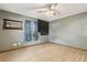 Spacious bedroom featuring wood-look tile, a ceiling fan, and a window with blue curtains at 1240 W Voorhis Ave, Deland, FL 32720