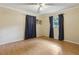 Inviting bedroom with hardwood floors and two windows dressed with stylish blue curtains at 1240 W Voorhis Ave, Deland, FL 32720