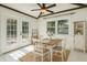 Sunlit dining room with white chairs, wood table, modern light fixture, and a view of the backyard at 1240 W Voorhis Ave, Deland, FL 32720