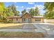 Charming single-story home boasts stone accents, solar panels, and a concrete driveway with decorative gravel walkway at 1240 W Voorhis Ave, Deland, FL 32720